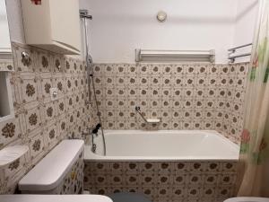 a small bathroom with a tub and a toilet at Chesa Chatrigna App 6 - Celerina in Celerina +10 photos