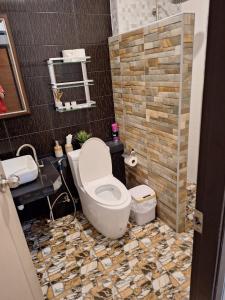 a bathroom with a toilet and a stone wall at Kamala cozy home in Kamala Beach +10 photos