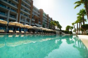 a swimming pool with umbrellas and a hotel at Hotel Morina Palace in Dhërmi