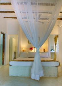 a bedroom with a bed with a canopy at Nyumba ya Bubi in Watamu