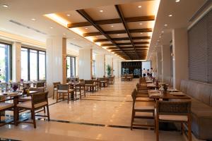 a dining room with tables and chairs and windows at Hotel Morina Palace in Dhërmi