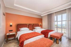 a hotel room with two beds and a window at Courtyard Hotel Gqeberha in Port Elizabeth +42 photos