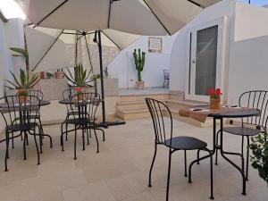 a patio with tables and chairs and an umbrella at Le Dune Luxury Rooms in Vieste