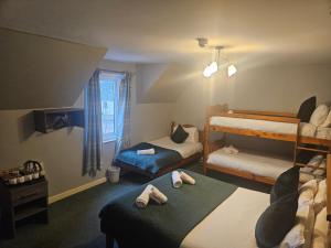 a bedroom with two bunk beds with towels on them at Tailrace Inn in Kinlochleven
