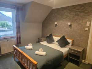 a bedroom with two beds with towels on them at Tailrace Inn in Kinlochleven