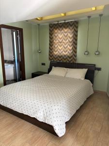 a bedroom with a large bed with white sheets at Uplift Hideaway Jacuzzi in Patra