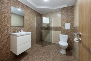 a bathroom with a toilet and a sink and a shower at Pensiunea Rosenau in Râşnov +29 photos