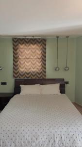 a bedroom with a large bed with two pillows at Uplift Hideaway Jacuzzi in Patra +2 photos
