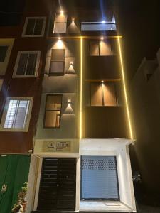 a building with lights on top of it at night at Spacious 2BHK Group Stay in Vijay Nagar, Indore in Indore