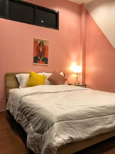 a bedroom with a large bed and a pink wall at SpamHouse Ranong in Ban Bang Rin (1)