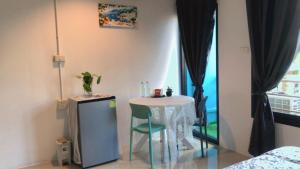 a small table and chair in a room with a window at SpamHouse Ranong in Ban Bang Rin (1)