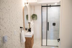 a bathroom with a sink and a shower with a mirror at Halifax's Most Popular Historic Modern Space in Halifax +21 photos