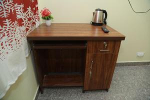 a wooden table with a coffee maker on top of it at serene cottage in Yelagiri