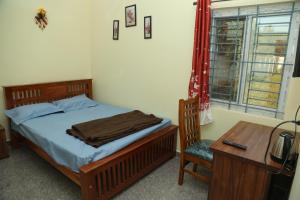 a bedroom with a bed and a desk and a desk at serene cottage in Yelagiri