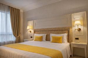 a bedroom with a large bed with two yellow pillows at Hotel President Venezia in Mestre +28 photos