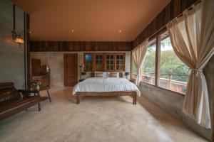 a bedroom with a bed and a large window at Cozy Home Saluang in Ban Lua Ka