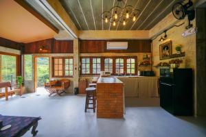 a kitchen with a refrigerator and a table in it at Cozy Home Saluang in Ban Lua Ka