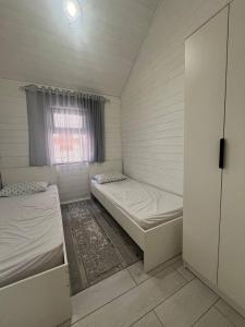 a small room with two beds and a window at Малинка in Cholpon-Ata