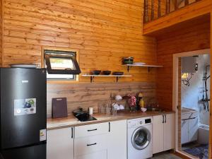 a kitchen with a refrigerator and a washing machine at Малинка in Cholpon-Ata