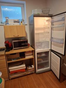 a kitchen with an open refrigerator with a microwave at Ubytovanie u Marty in Martinske Hole