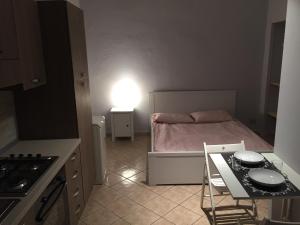 トリノにあるMonolocale Torinoの小さなベッドルーム(ベッド1台、テーブル、椅子付)