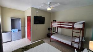 a bedroom with two bunk beds and a flat screen tv at I Love Combate Rooms & Suites in Boqueron