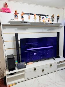 a shelf with a television and toy figurines on it at Manzanares Homestay in San Jose