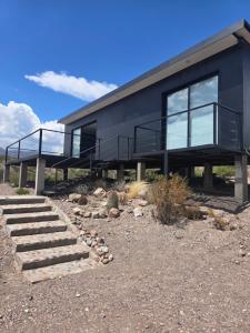 a black house with stairs in front of it at Altos Dique Potrerillos in Potrerillos