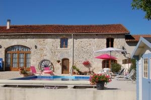 a house with a swimming pool and an umbrella at La Grange in Yviers