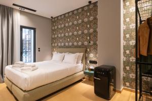a bedroom with a large white bed and a wall at Athens Retro in Athens