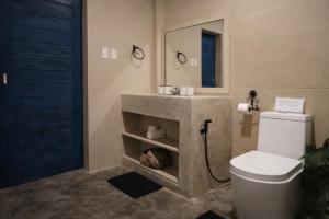 a bathroom with a sink and a toilet and a mirror at Sleepy Gypsea Villa Siargao Swell in Catagnan