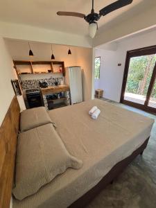 a bedroom with a large bed and a stove at CASA NANDOS Studio quintal da mata !!! in Itacaré +32 photos