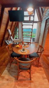 a dining room with a wooden table and chairs at Chalé Nascer do Sol 2 in Massaranduba +27 photos