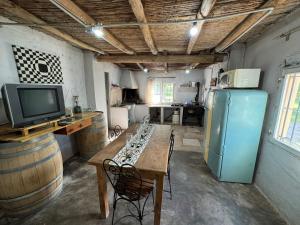 a kitchen with a wooden table and a refrigerator at Maju in Calingasta