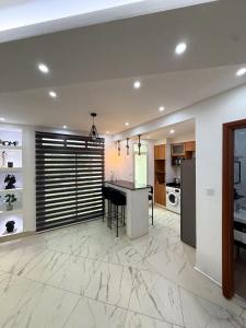 a kitchen with white marble flooring and a table at Bel appartement a Yaoundé Bastos in Yaoundé