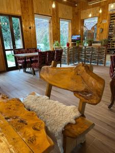 a room with a table and chairs and a wooden floor at Bujtina Alpine Vanat in Bele