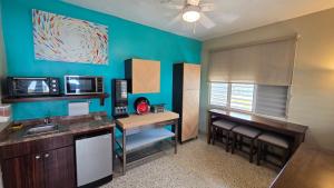 a room with a kitchen with a sink and a desk at I Love Combate Rooms & Suites in Boqueron