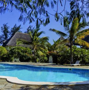 a swimming pool in front of a house with palm trees at Nyumba ya Bubi in Watamu