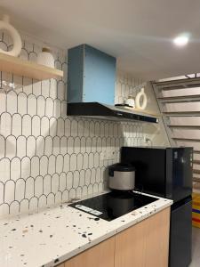 a kitchen with white tiled walls and a black appliance at Dana Home MT in Danang