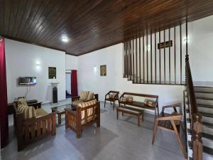 a living room with chairs and tables and a tv at Meadow Villa - Ella in Ella