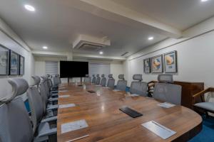 a conference room with a large wooden table and chairs at Hotel TGR in Ankleshwar
