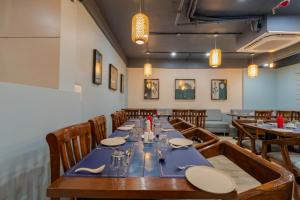 a dining room with a long table and wooden chairs at Hotel TGR in Ankleshwar