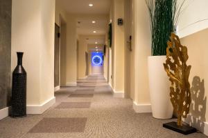 a hallway in a building with plants and a blue light at Hotel Botanica in Belgrade