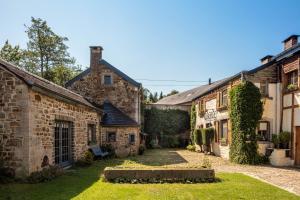a row of old stone buildings in a yard at Auberge du Val d'Aisne in Fanzel