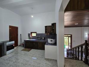 a kitchen with white walls and wooden cabinets at Meadow Villa - Ella in Ella