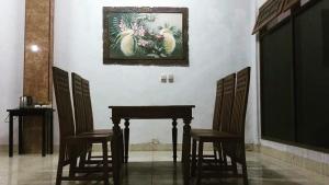 a table and chairs with a picture on the wall at Ratih Bali Hostel in Denpasar +23 photos