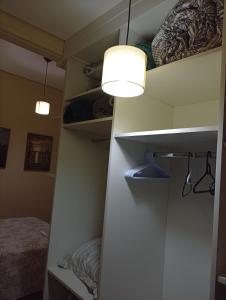 a room with a closet with a light and a bed at Quarto Suite & Cozinha in Piraju