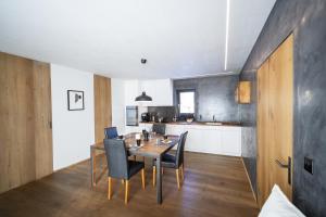 a kitchen and dining room with a table and chairs at Chasa Vital in Sent