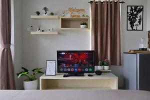 a television sitting on a table in a bedroom at Soft Reset Room by YOMAIN in Kemirimuka Tiga