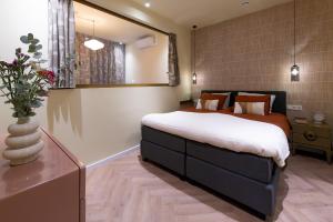 a bedroom with a large bed and a vase with flowers at Gelk in Groningen